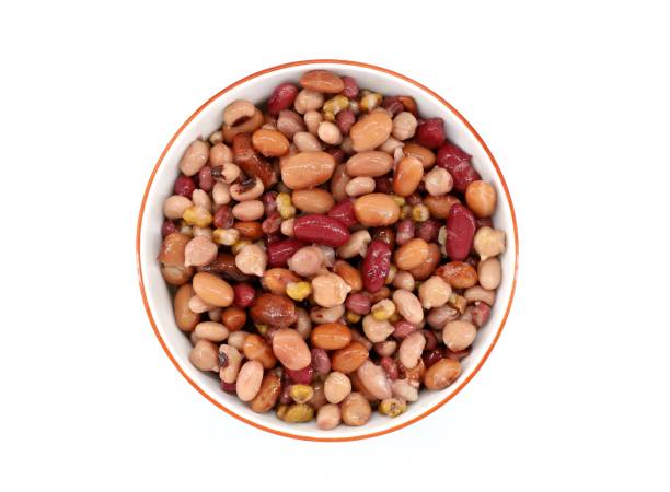 Mix of boiled legumes in a ceramic bowl. Legumes are chickpeas, different varieties of beans and azuki. Mix of boiled legumes in a ceramic bowl. Legumes are chickpeas, different varieties of beans and azuki. White background, top view. organic red cowpea beans stock pictures, royalty-free photos & images