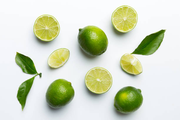 istock Lime fruits with green leaf and cut in half slice isolated on white background. Top view. Flat lay with copy space 2032185044