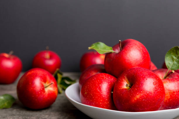 istock juicy red apples in a bowl or plate on the table top view. Copy space 2032185048