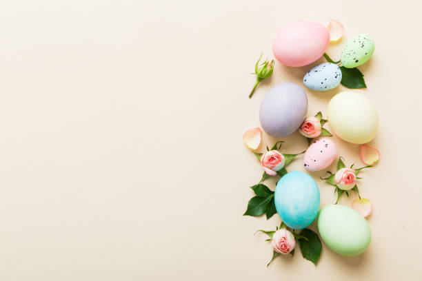 istock Happy Easter. Easter eggs on colored table with yellow roses. Natural dyed colorful eggs background top view with copy space 2032186152