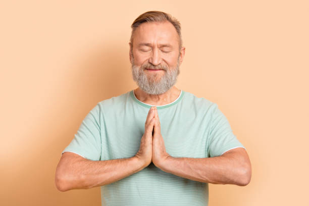 istock Photo of focused concentrated man showing two hands together dreaming prying asking help isolated on beige color background 2032201852