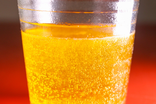 Front view view of orange fruit and glass of orange juice on white background.