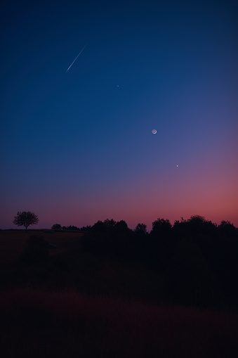 Crescent Moon, falling star, planet conjunction and landscape scenery silhouettes.