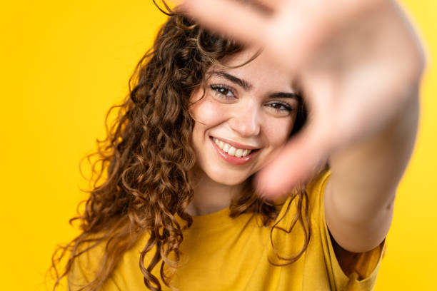 istock Young Woman smiling with hand up 2032229573
