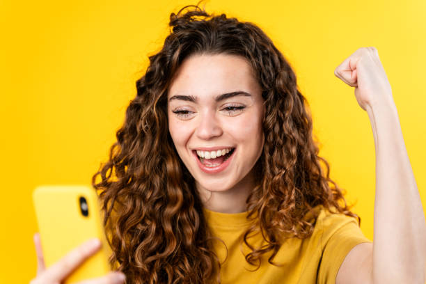istock Joyful Woman with Smartphone Victory 2032232279
