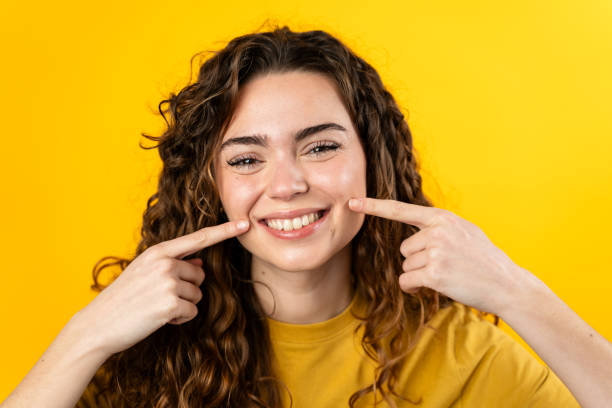 istock Smiling Woman Pointing to Cheeks 2032232291