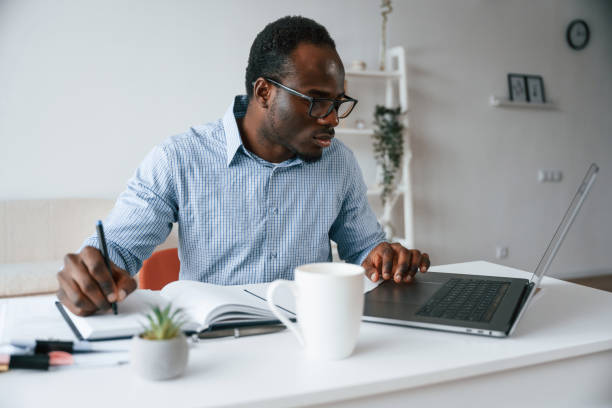 istock Doing some paperwork. Businessman is in the office by laptop 2032245682
