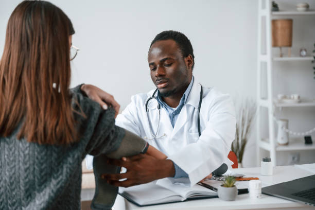 istock A doctor measures a young woman's blood pressure 2032249486