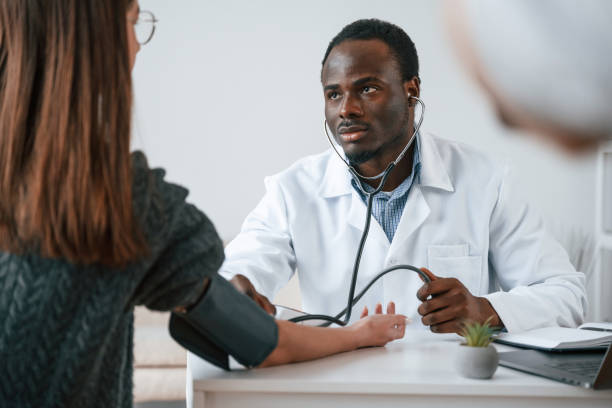 istock Customer service. A doctor measures a young woman's blood pressure 2032250002