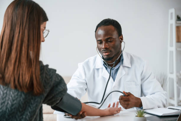 istock Customer service. A doctor measures a young woman's blood pressure 2032250008