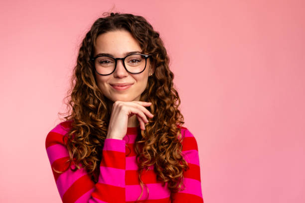 istock Curly-Haired Woman Posing with Hand on Chin 2032255443