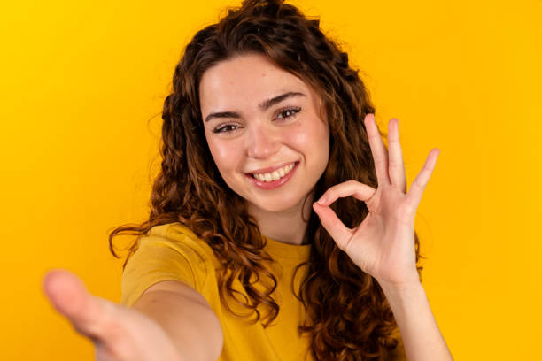 istock Happy Woman Gesturing OK and Reaching Out 2032262387