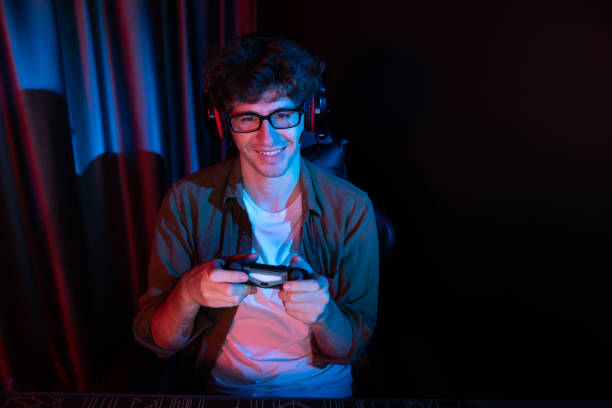 istock Smiling streamer with joystick, focusing Esport team on pc with harder. Gusher. 2032266723