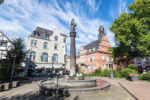 Essen, Germany - August 21, 2022: The historic Werdener Markt with St. Ludgerus-Brunnen fountain and town hall in the heart of suburb Werden in Essen-Werden, North Rhine-Westphalia, Germany.
