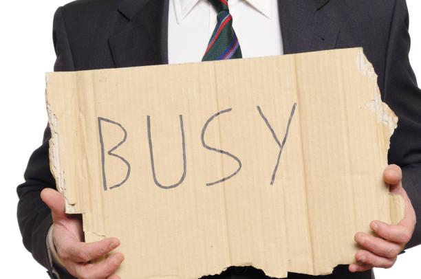 Businessman holding busy sign. Cut out.