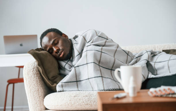 istock Lying down on the sofa. Sick black man is at home 2032277692