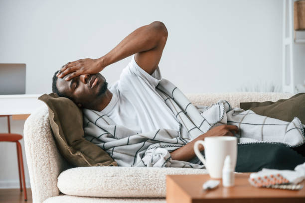 istock Lying down on the sofa. Sick black man is at home 2032278221