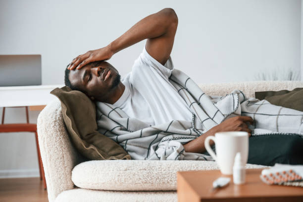istock Lying down on the sofa. Sick black man is at home 2032278222