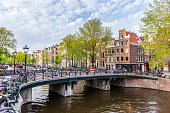 Amsterdam downtown - Amstel river, old houses and a bridge. Nice view of the famous city of Amsterdam. Travel to Europe.