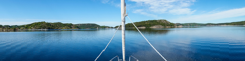 Gothenburg Archipelago in all its glory from a boat on a clear spring day, enjoy scenic views of the vibrant islands, tranquil waters, and the North Sea. Immerse yourself in the beauty of this Swedish maritime wonderland.