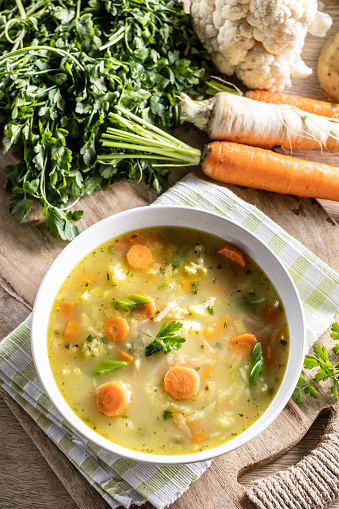 Spring vegetable soup with chopped and grated root vegetables, seasoned with yeast. Healthy vegetable vegetarian food.