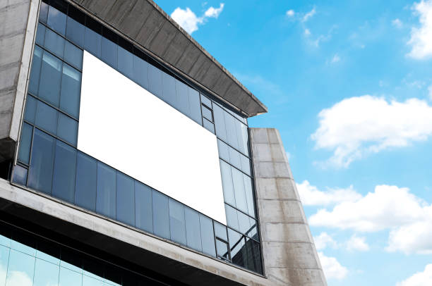 istock Mock up white horizontal billboard on mirror wall building with blue sky background .clipping path for mockup 2032311998