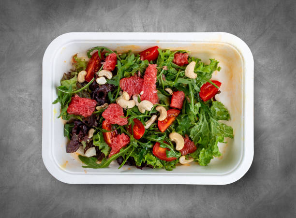 istock Juicy salad with grapefruit and arugula. Healthy diet. Takeaway food.  Top view, on a gray background. 2032319607