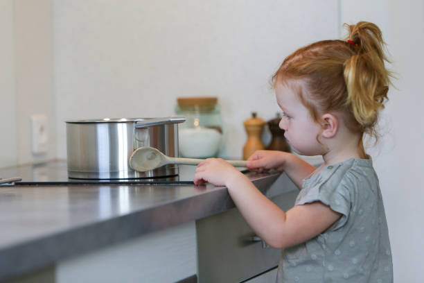 istock Little girl in a kitchen with a saucepan 2032321240
