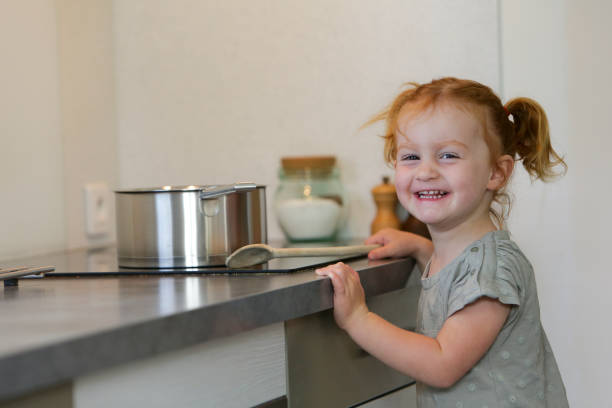 istock Little girl in a kitchen with a saucepan 2032321244