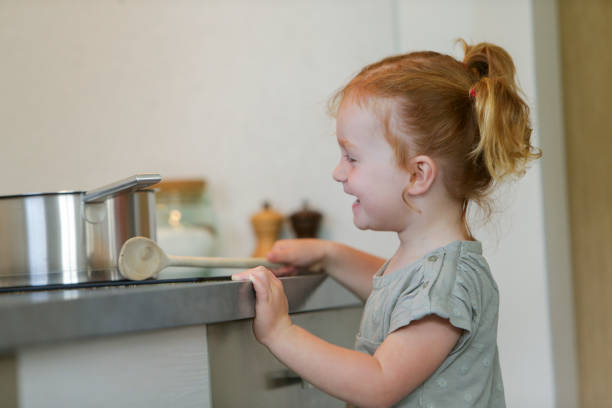 Little girl in a kitchen with a saucepan stock photo