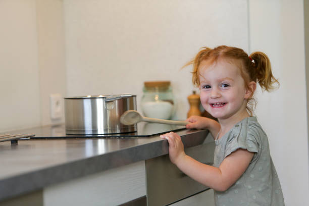 Little girl in a kitchen with a saucepan stock photo