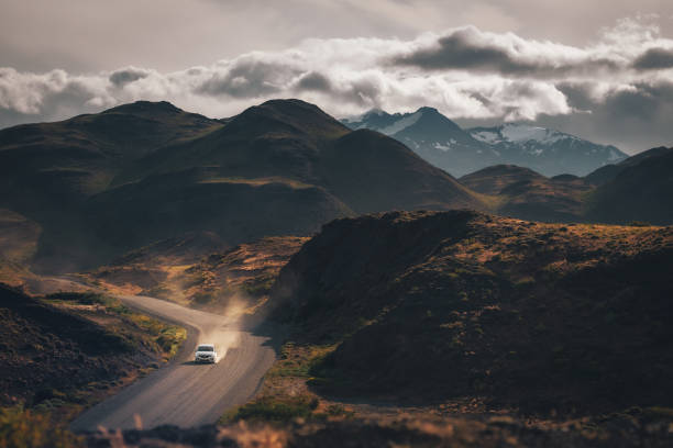 istock A moving car surrounded by the mountains with beautiful sky and dramatic cloud (Torres del Paine, Patagonia, Chile) 2032332626