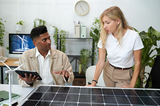 Diverse team of engineers discussing solar panel output
