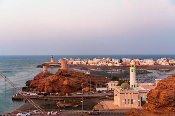 parte oeste da cidade de sur com o farol de al-ayjah e o castelo de al-ayjah na hora dourada, omã - oman town arabia arabian peninsula - fotografias e filmes do acervo
