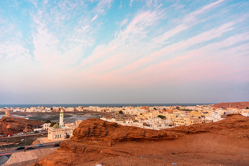 West part of Sur town with Al-Ayjah Castle, mosque in golden hour, Oman. View from high point of the city of Sur. Wide angle