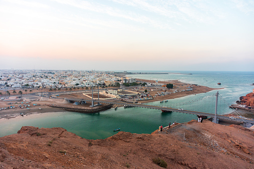 Panoramic view on west part of the Sur city in golden hour. Al Ayjah Bridge, Sur Province, Sur, Oman