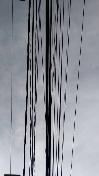 istock Appearance of long hanging electrical cables against a blue sky background 2032360120