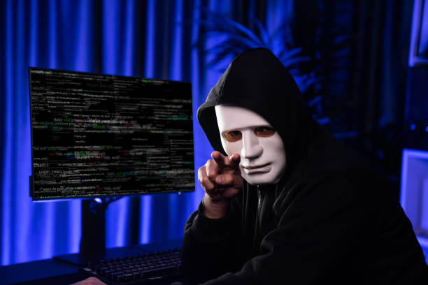 istock White criminal anonymous mask pointing to camera, provoke as hacker. Surmise. 2032375685