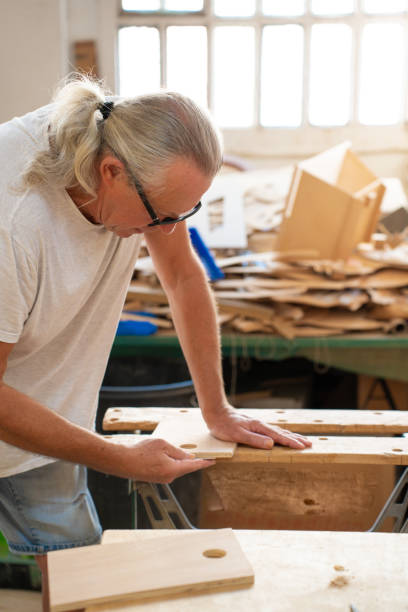 istock Professional elderly man carpenter artist working on wood using carpentry tools in the workshop 2032377357