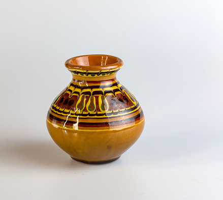 Clay vase with painting for flowers on a white background.