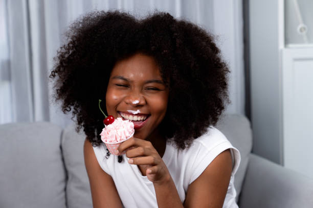 istock Funny African on mess face presenting cupcake in concept special. Tastemaker. 2032380382