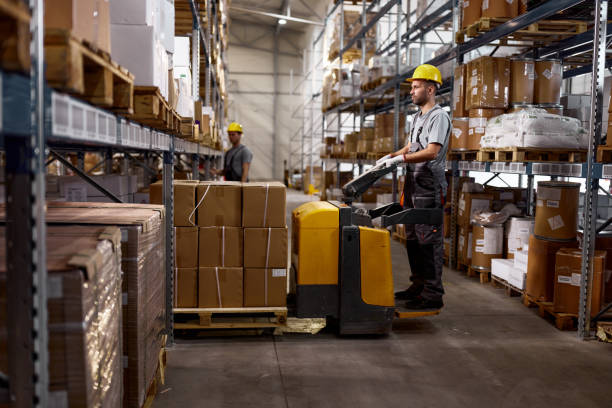 Warehouse worker working with pallet jack in a storage room.