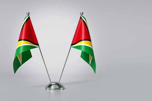 Double Co-operative Republic of Guyana Table Flag on Gray Background. 3d Rendering