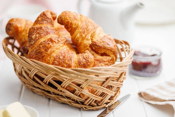 istock Baked tasty croissants in basket on white table. 2032421923