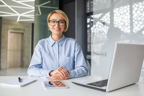istock Satisfied woman with short haircut folding hands on desk with computer and notebook with pen. Smiling hr manager getting ready for interview and welcoming new candidate for position in company. 2032460962