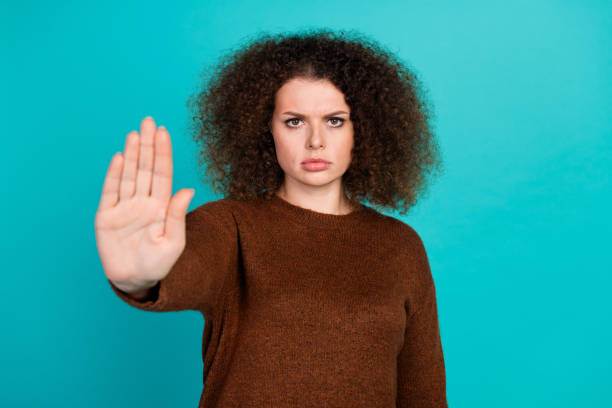 istock Photo of young upset lady wearing brown pullover makes negative symbol asking stop agism problem isolated on aquamarine color background 2032470528