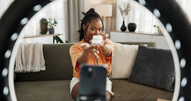 Video, influencer and black woman doing skincare for tutorial on social media or the internet. Dermatology, happy and young African female person filming or live streaming facial routine at home.