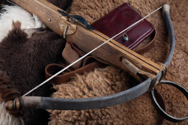 Archer in historical costume aims longbow at a target during a Medieval Fair during a lively costumed festival at the local community event. High quality photo