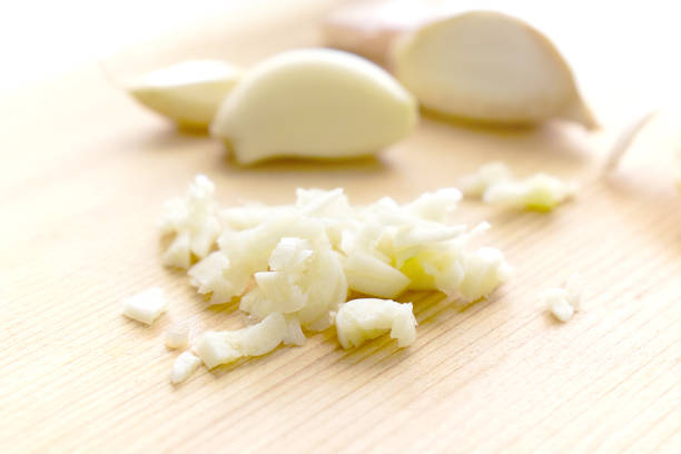 istock Minced garlic and garlic cloves on chopping board. 2032491440