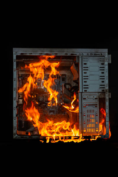 istock computer unit is burning with open fire and smoke from overheating, on a black isolated background 2032494112